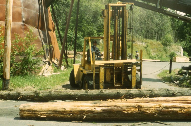 Danny Waterman moving Cedar logs for pick up by Bradley Construction.